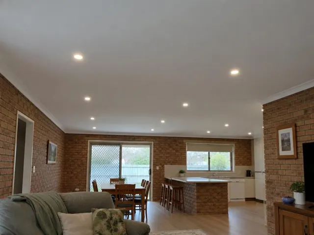 Ceiling with recessed LED downlights in a brick-walled open-plan home in Floraville